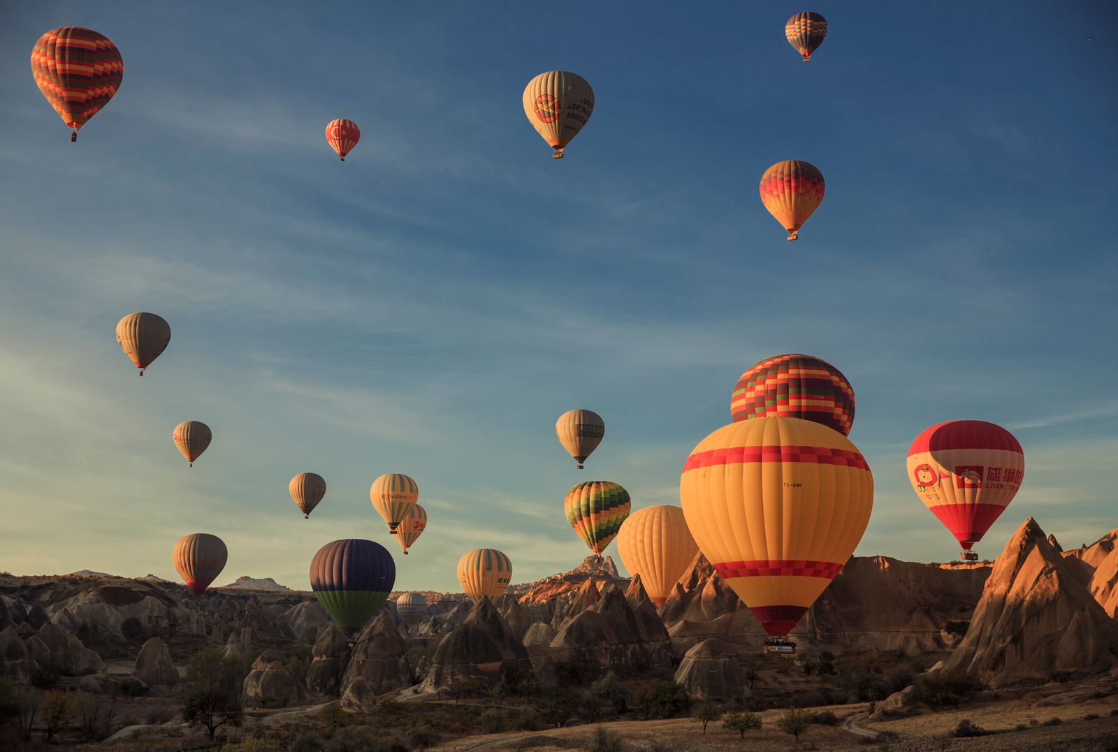 Hot air balloons rising over the valleys of Cappadocia at sunrise