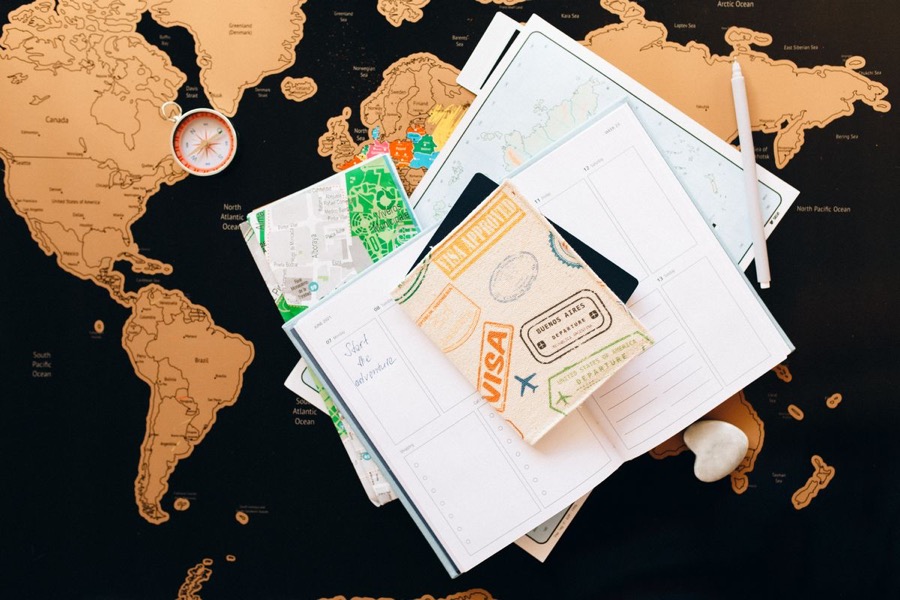 A passport, planner and map laid out ready for a trip